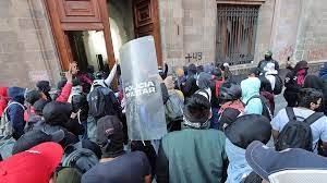 Manifestantes derriban puerta de Palacio Nacional en protesta por caso Ayotzinapa.